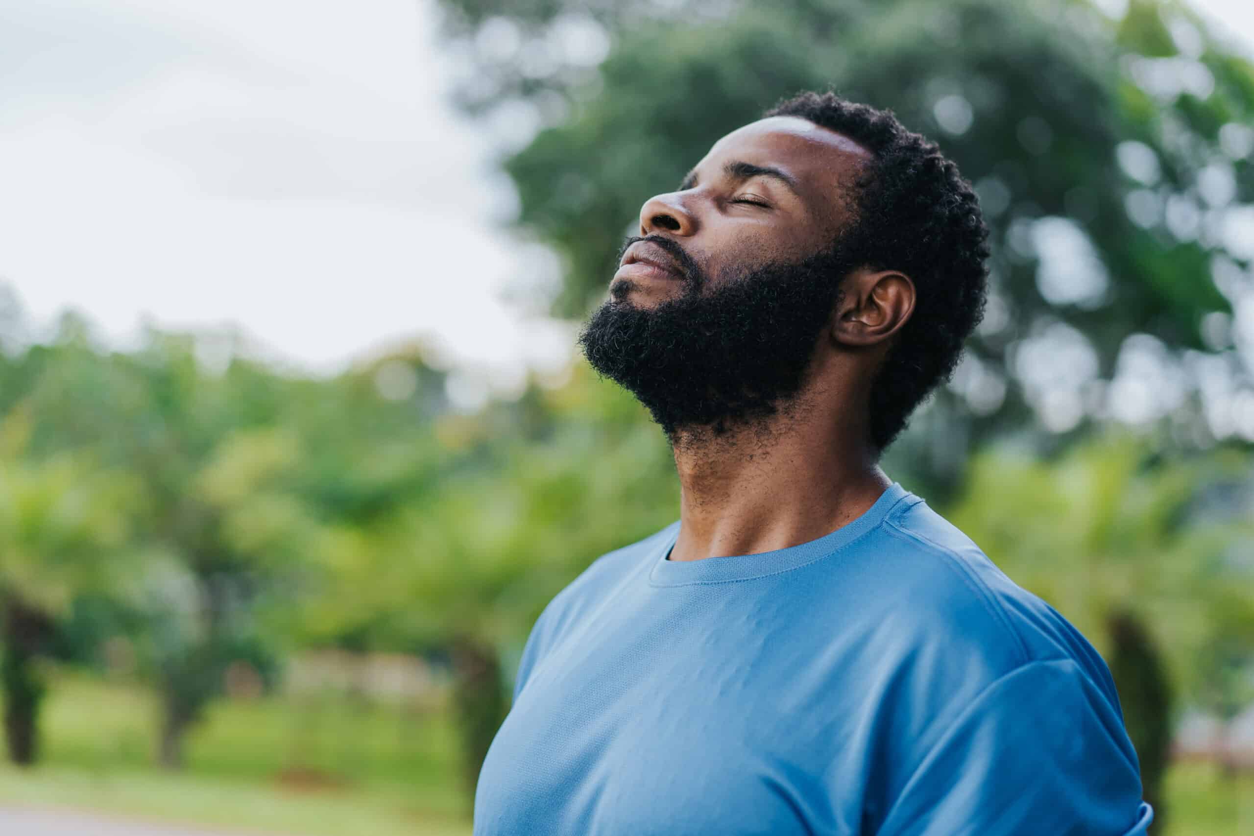 Portrait of a man breathing in fresh air in nature, enjoying the benefits of tree care.